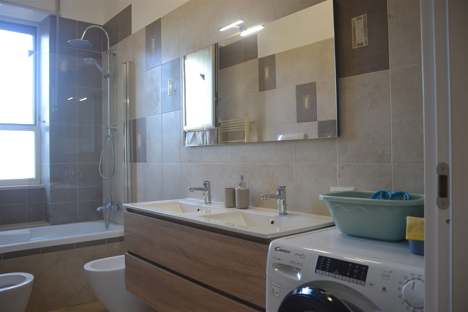 Bagno con doccia, doppio lavabo e lavasciuga